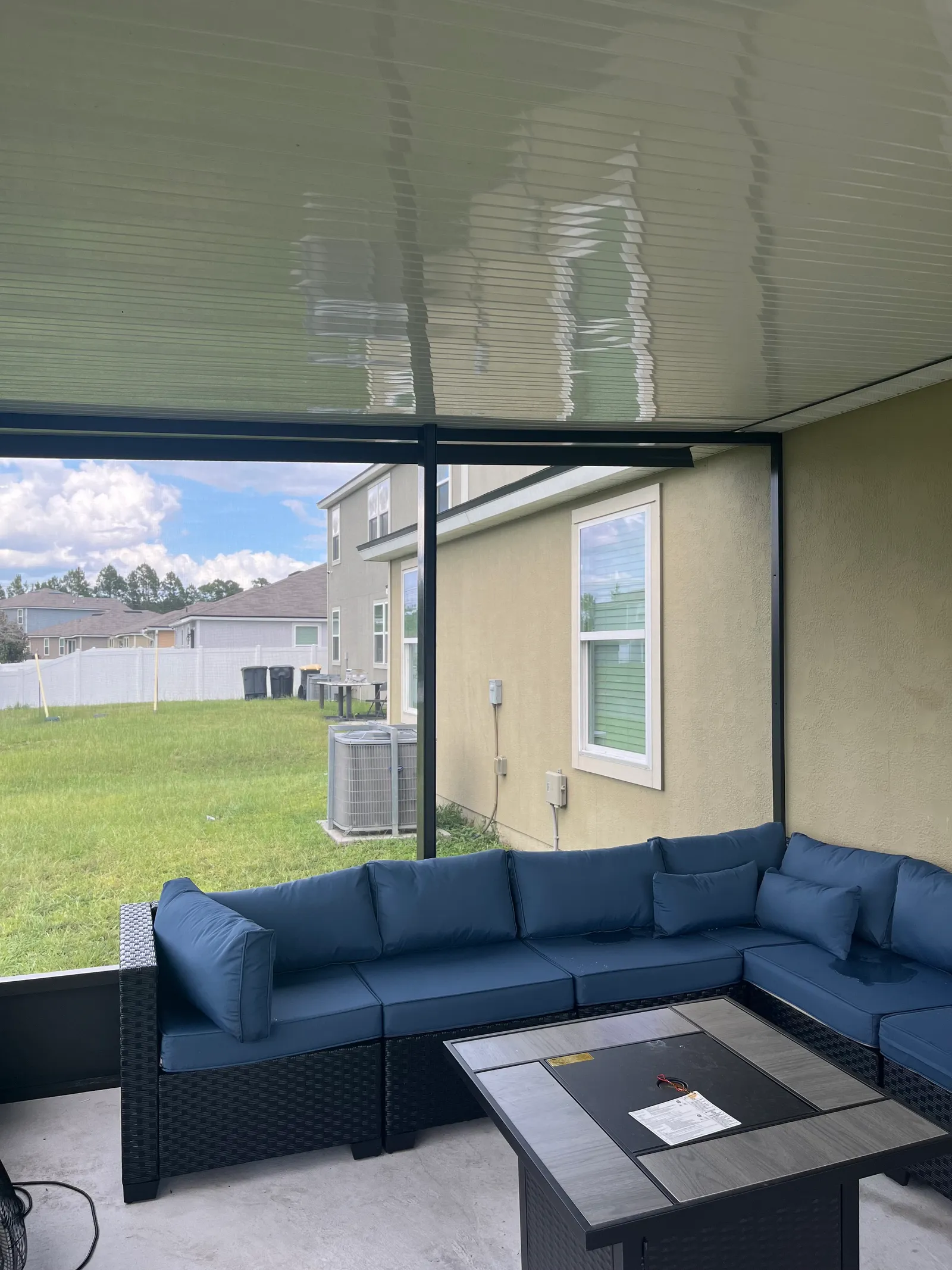 Inside a finished screen room with a sectional and fire table in Greater Jacksonville, FL